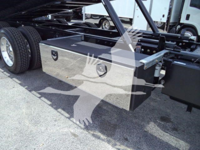 Kenworth T880 rollback truck chassis showing a metal toolbox mounted under the frame with dual latches.