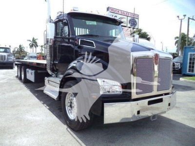 Kenworth T880 rollback truck in black and chrome, front three-quarter view showing large grille, bumper, and dual rear axles.