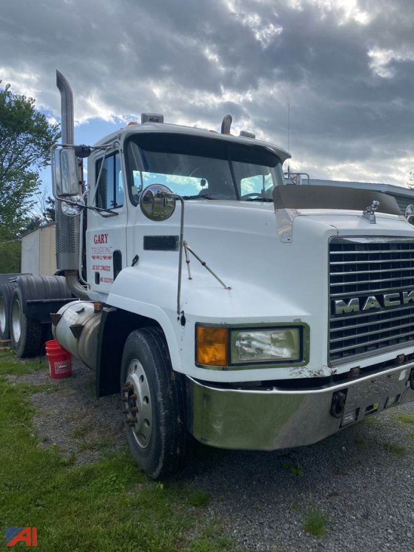 Mack CH613 semi tractor cab in view showing front grille, headlights, and chrome bumper with mirrors; white exterior with black tires.