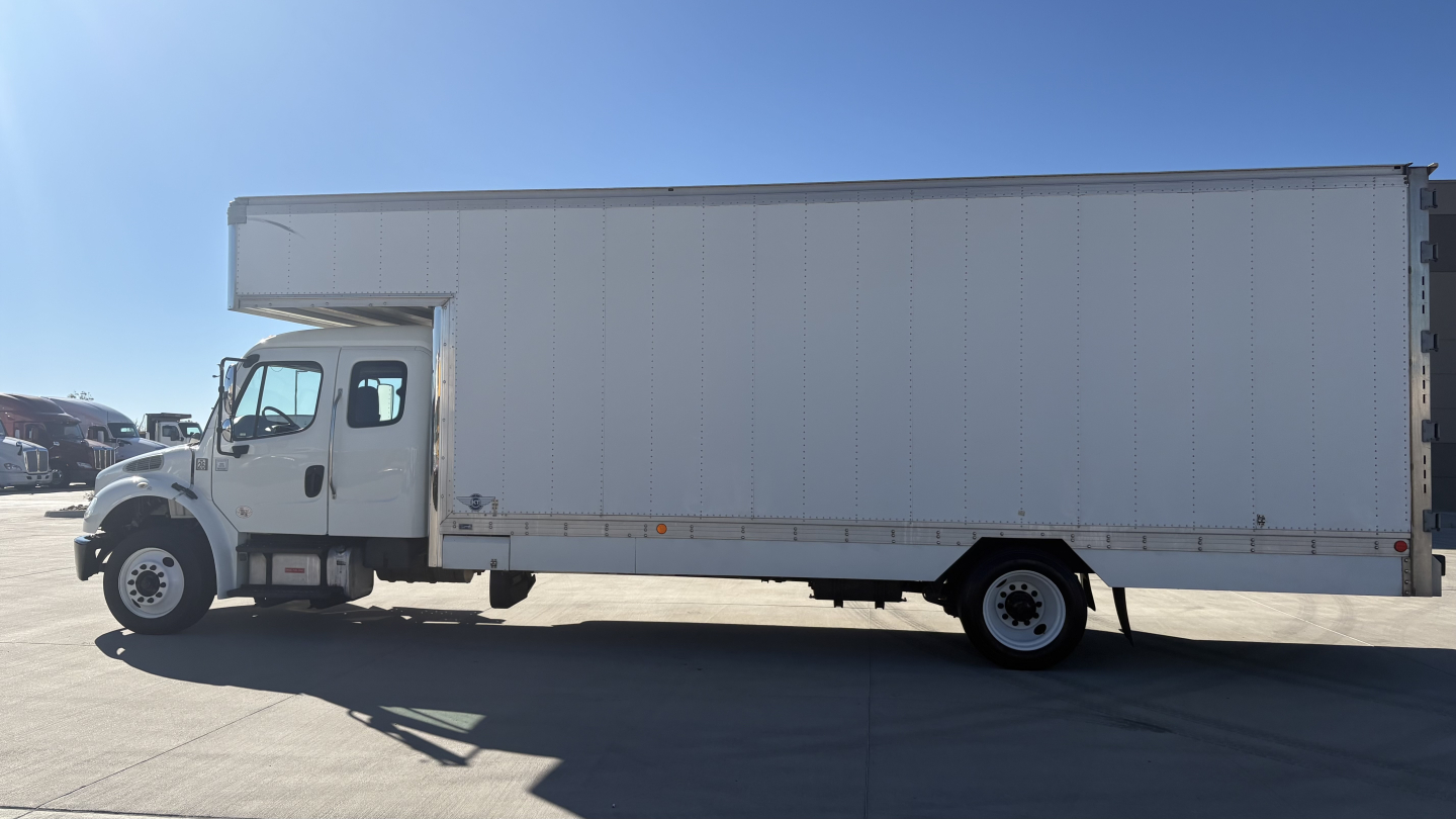 Freightliner M2-106 box truck side view showing cab and long cargo box with clean lines.