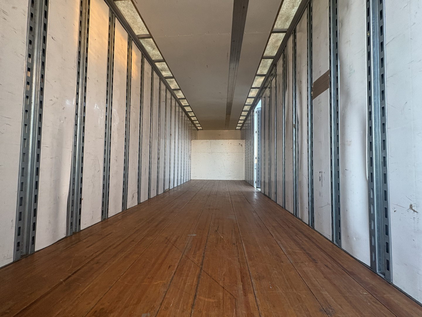 Freightliner M2-106 box truck interior cargo area showing wooden floor and side wall rails.