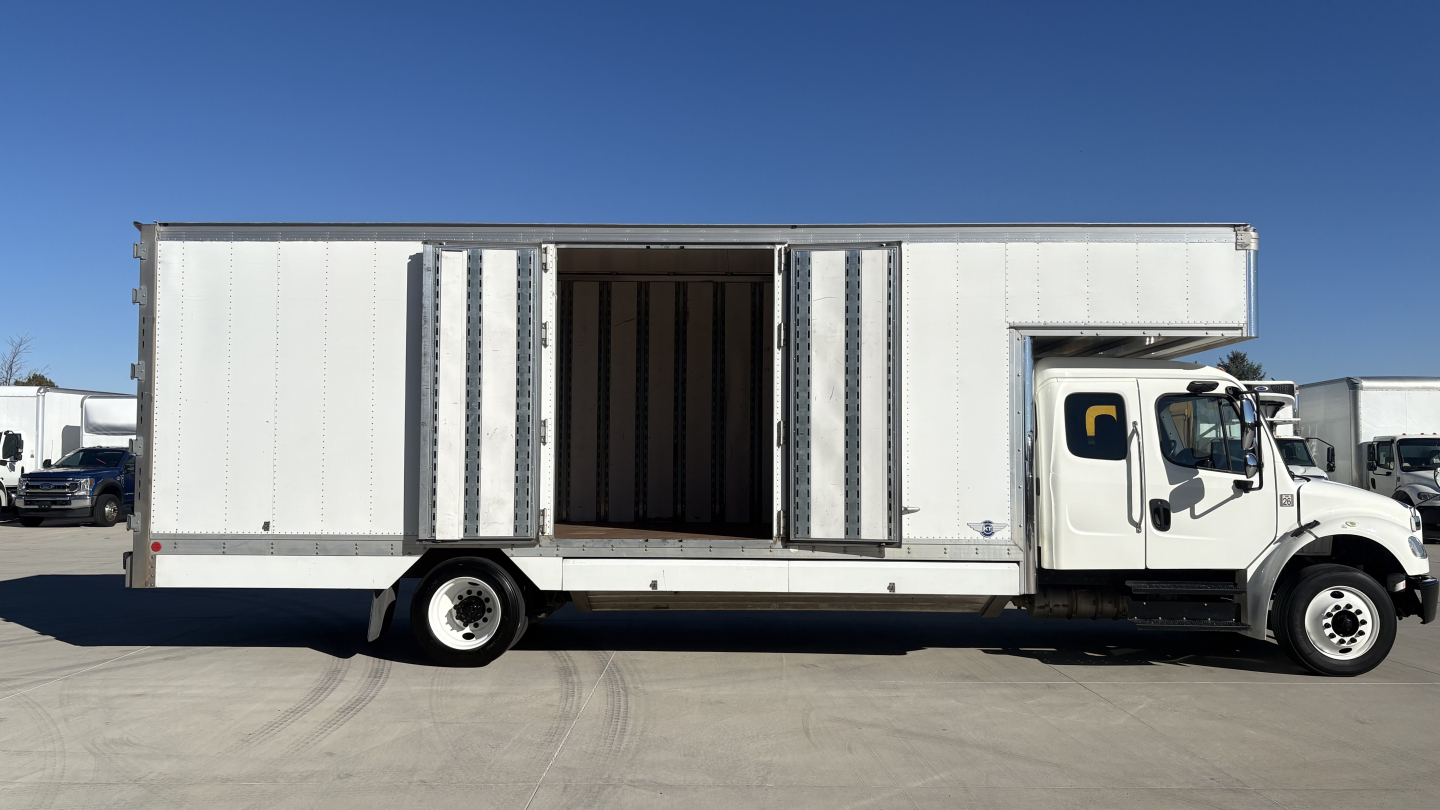 Truck side view of a 2019 Freightliner M2-106 box truck with cargo area doors open.