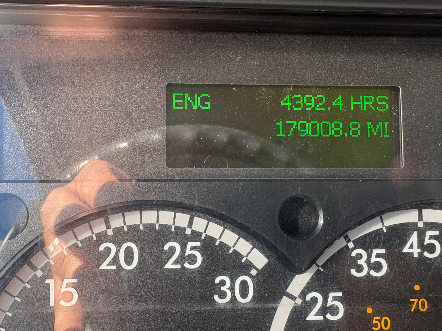 Dashboard display of a Freightliner M2-106 showing engine hours 4392.4 and miles 179008.8 along with partial gauge cluster.