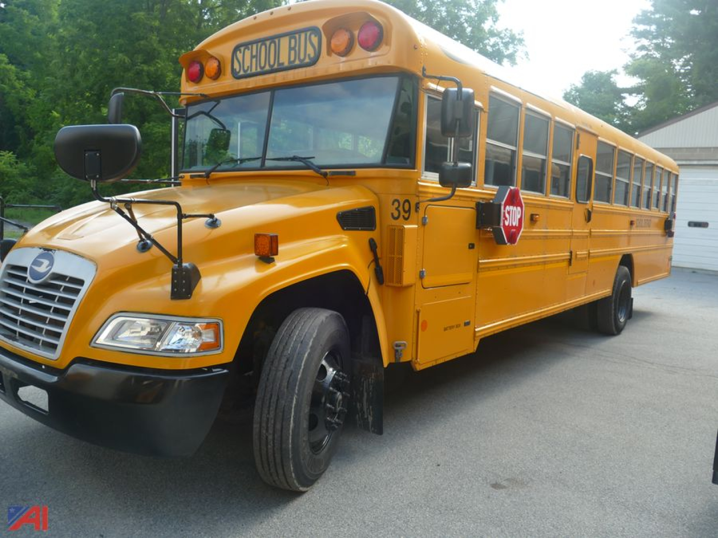 Yellow 2016 Blue Bird Vision school bus with stop sign out, front left angle view, bus number 39, chrome front grille, black bumper, large side mirrors.