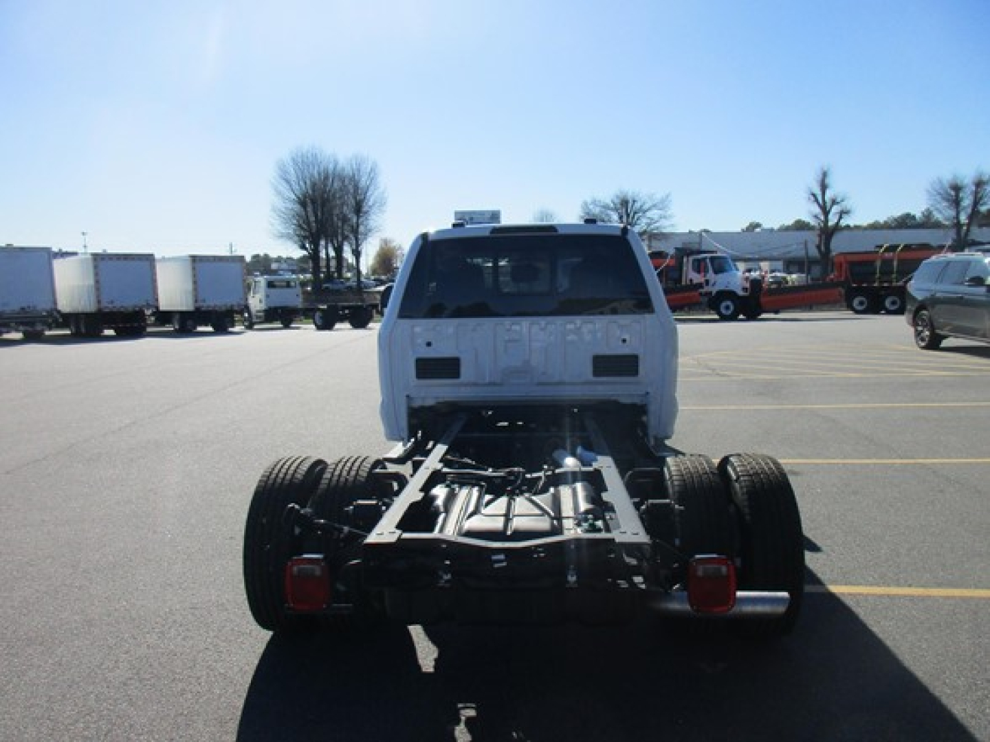 Trucks cab chassis rear view showing chassis frame and rear wheels with Ford cab in distance.