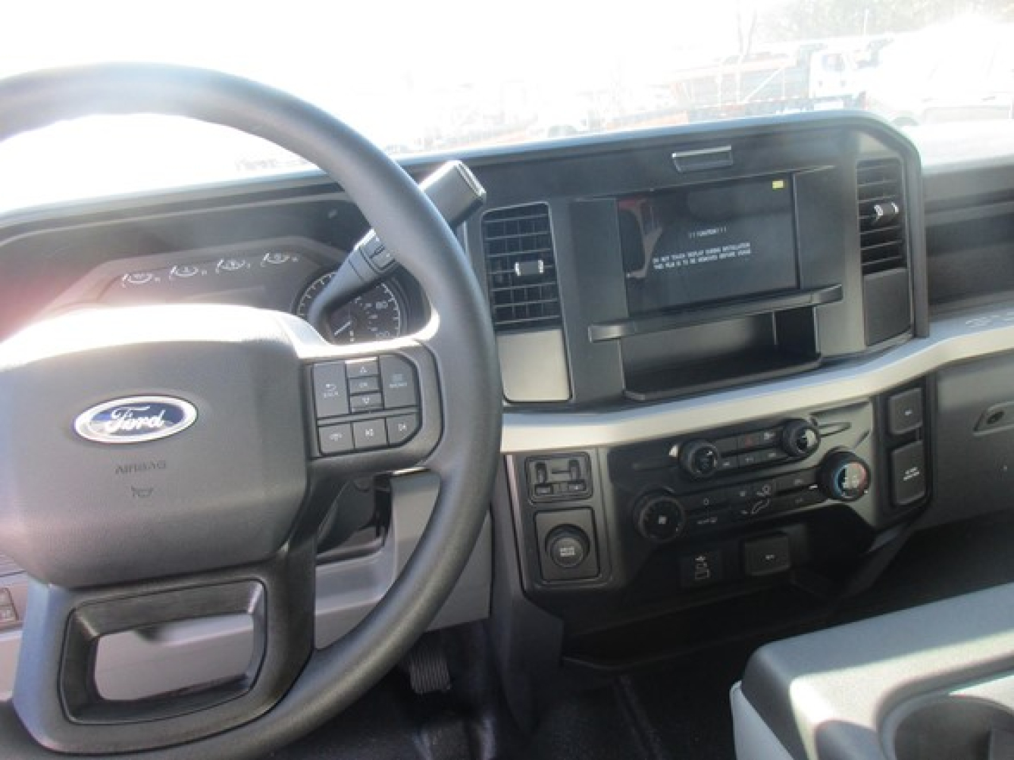 Ford F-350 interior dashboard and steering wheel showing steering wheel controls and center console.