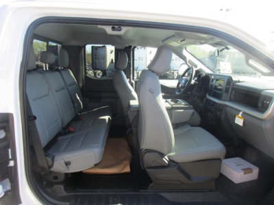 Ford F-350 cab and chassis interior showing front bucket seats and rear bench seating, light gray upholstery, dashboard and steering wheel visible.