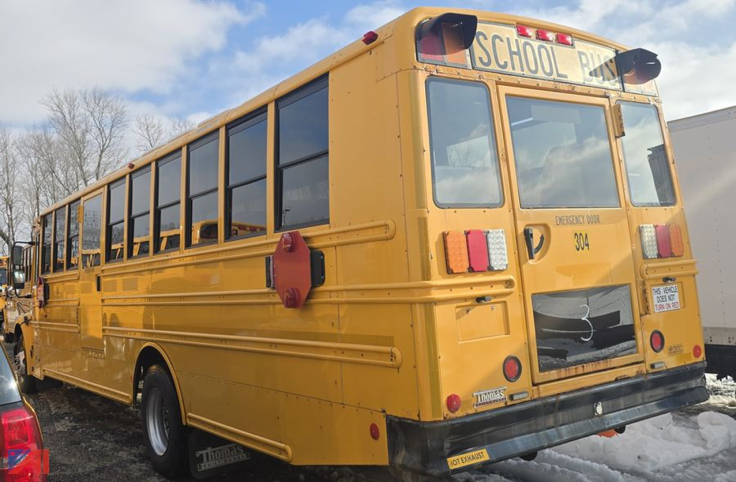 School bus 2014 Freightliner B2 bus rear view showing yellow body and back doors with red reflectors.