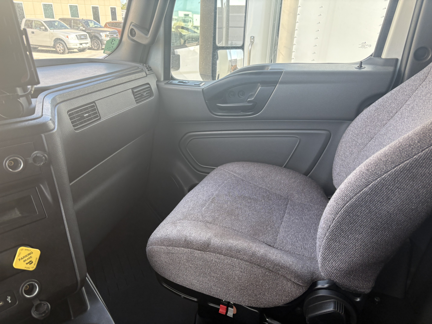 Cab interior of a used 2023 International LT625 truck showing front passenger seat and dashboard area.