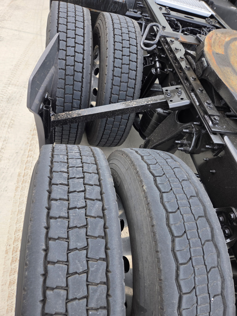 Dual rear axles showing treaded truck tires and suspension components in an International LT625.