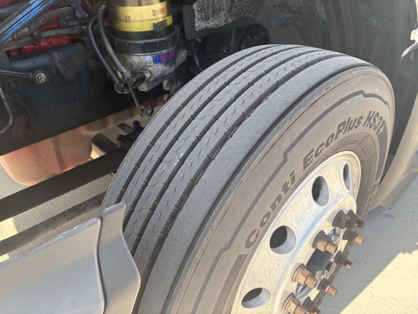 Wheel/view of front tire on International LT625 with dual tread and liner, showing Conti EcoPlus HSS tire and wheel hub; suspension and brake components visible.