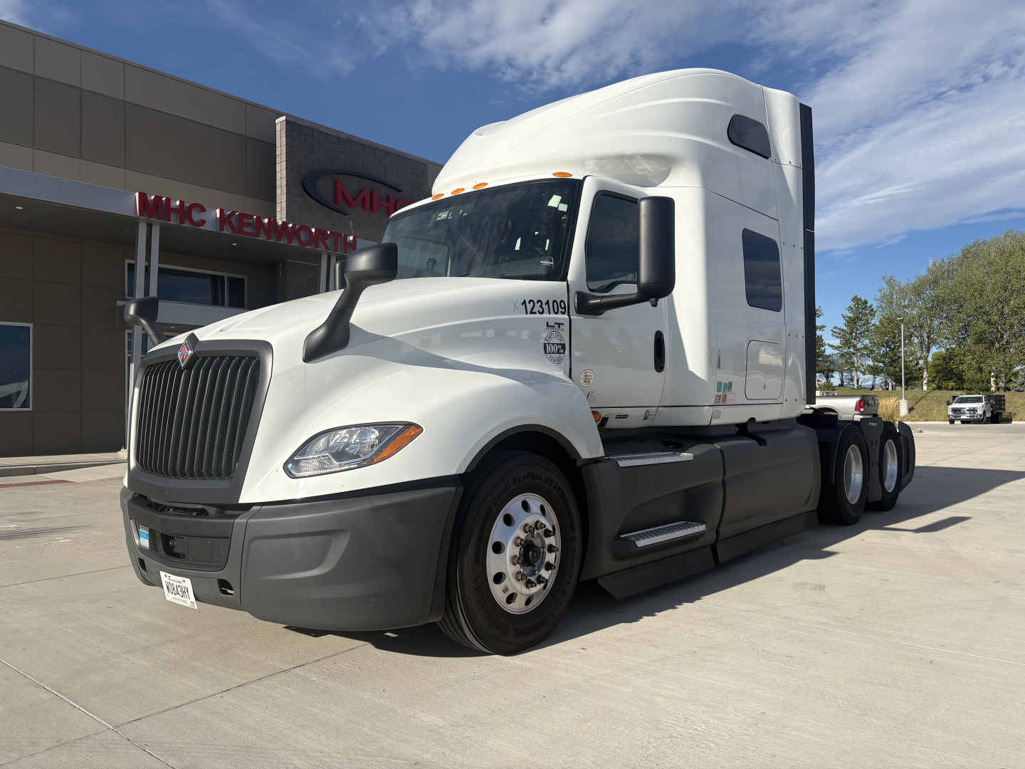 Truck cab exterior with International LT625 badge, white sleeper tractor in a dealership lot, front grille, dual rear axles, VIN 3HSDZAPR0PN576519 visible on listing.