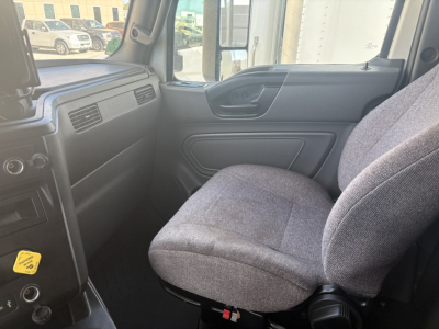 Cab interior of a used 2023 International LT625 truck showing front passenger seat and dashboard area.