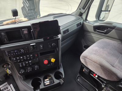 Cab interior of 2023 International LT625 truck showing dashboard controls, infotainment screen, knobs, and driver seat.