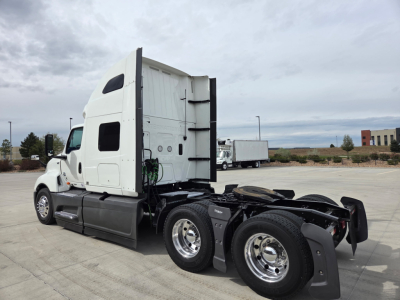 Truck rear shows fifth wheel and dual rear axles with white sleeper cab and chrome wheels.