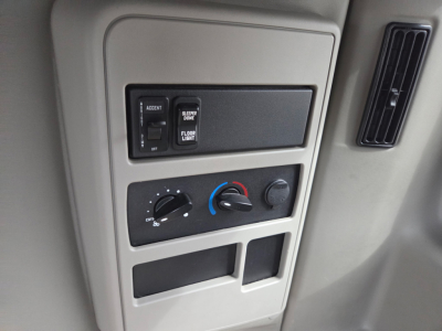 Truck interior dash panel with climate controls and storage compartments visible in center, plus vertical vent to the right.
