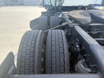 Twin rear tires of a truck chassis with suspension and fuel tanks visible; no legible serials or labels discernible in the image.