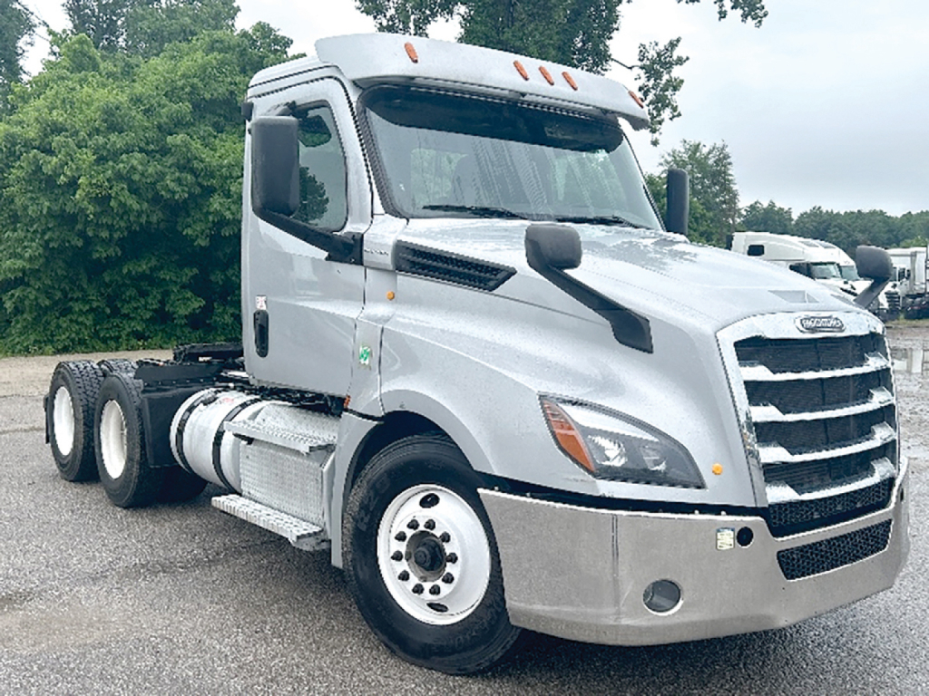 Truck cab area of a 2020 Freightliner Cascadia126 conventional daycab shown from front-left angle with gray paint and chrome grille.