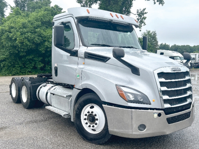 Truck cab area of a 2020 Freightliner Cascadia126 conventional daycab shown from front-left angle with gray paint and chrome grille.