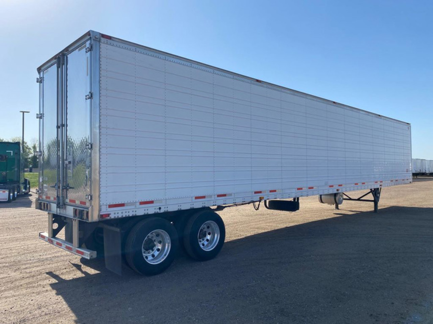 Trailer side view of a 2020 Wabash refrigerated trailer showing smooth aluminum panels and double rear doors.