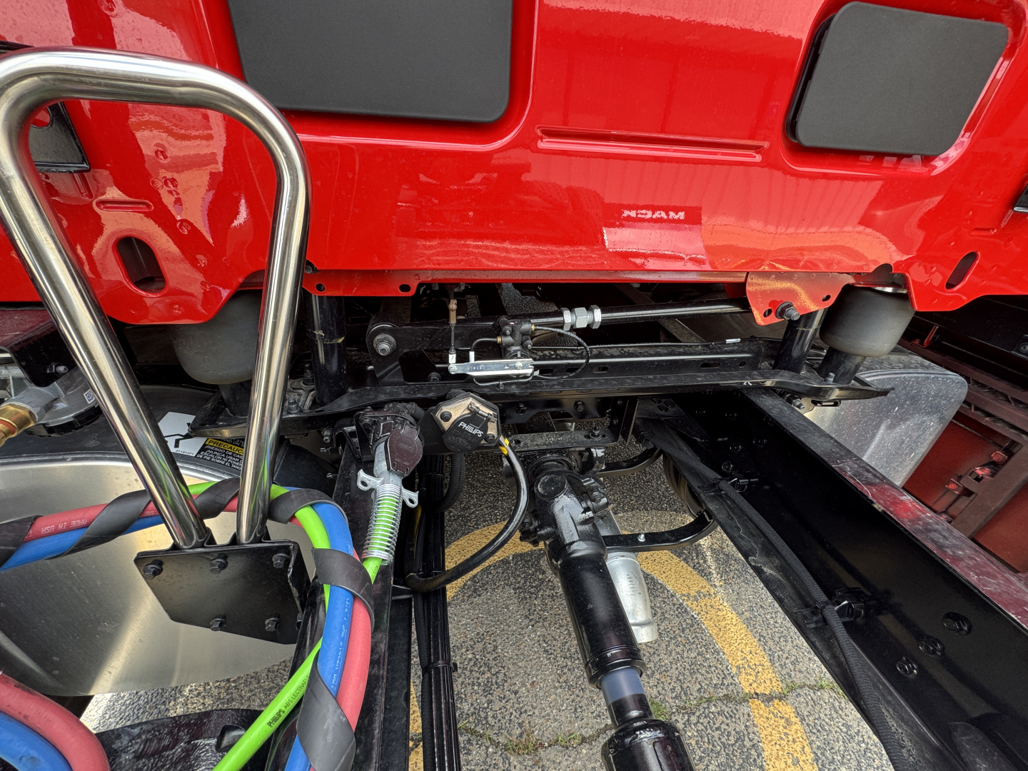 Mack PR64T76H truck chassis view under cab showing suspension and drive components.