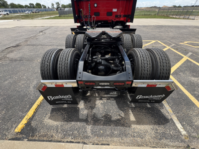 Truck rear view showing fifth wheel and dual rear axles on a Mack PR64T76H tractor with dual mud flaps and license-plate area, stock 72597.