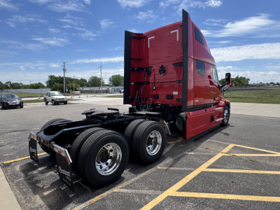 Truck tractor in red showing rear and dual rear axles with fifth-wheel and chassis components visible