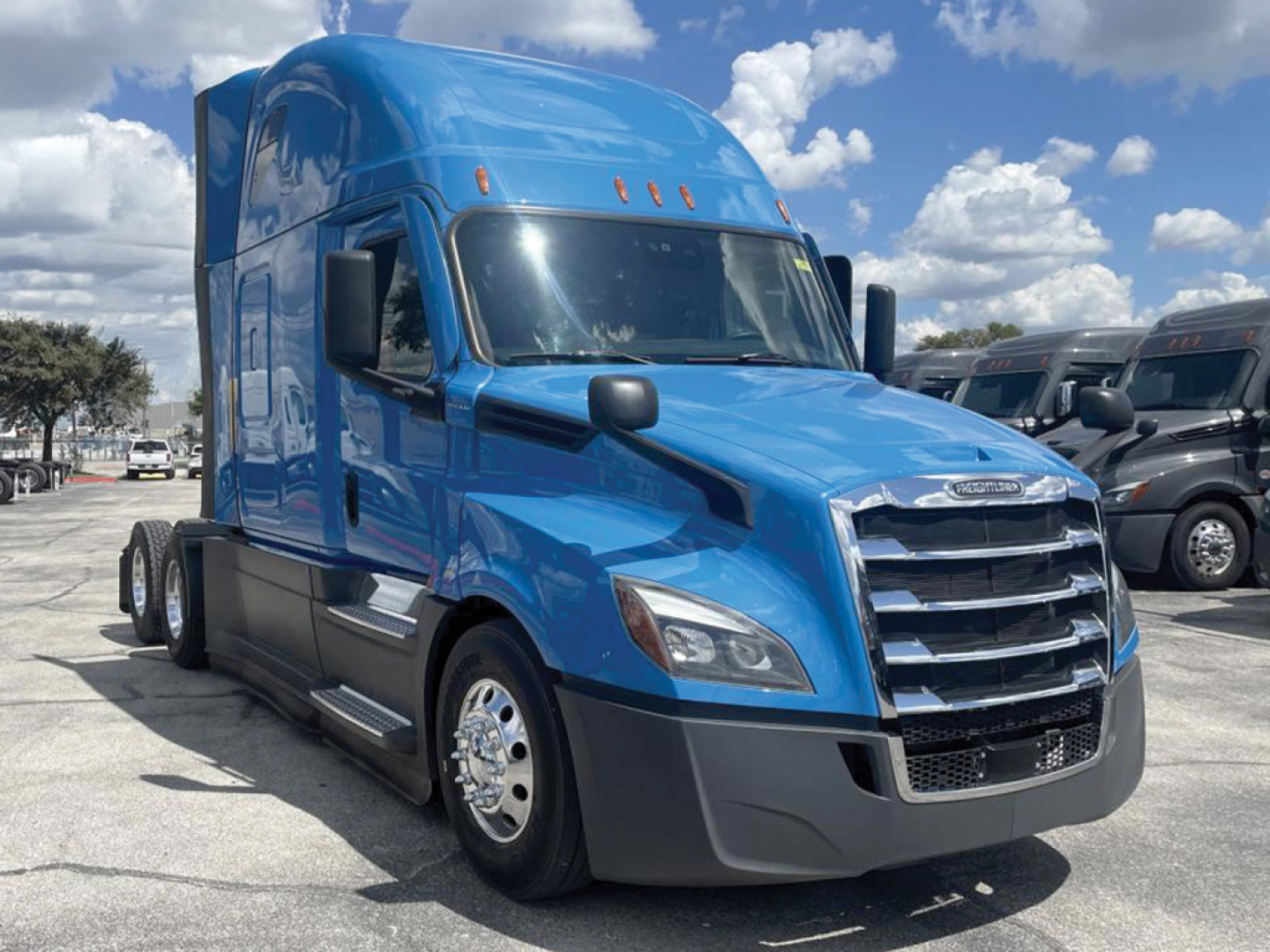 Freightliner Cascadia126 sleeper cab tractor in blue, front three-quarter view, with chrome grille, large side mirrors, and dual rear axles.
