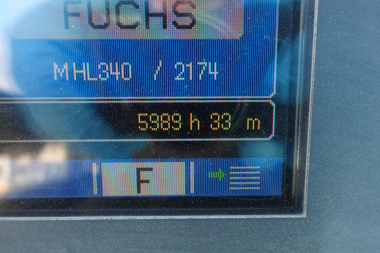 Loader displays Fuchs MHL340D with hours 5869 h 83 m, model MHL340 / 21?4? on screen, in-service indicator.