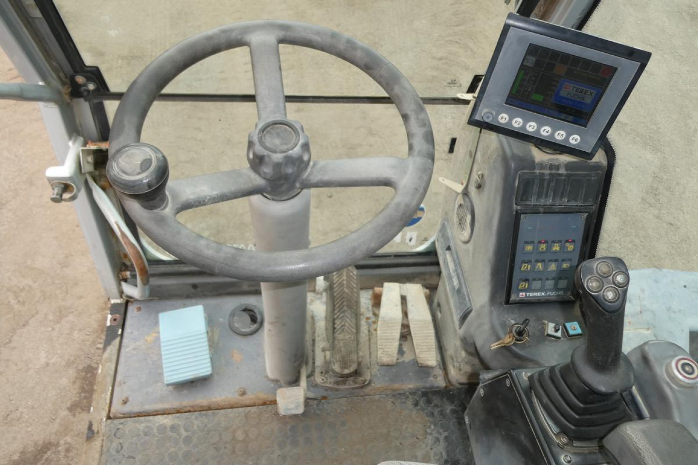 Terex MHL340D operator cab showing steering wheel, pedal controls, and digital display panel