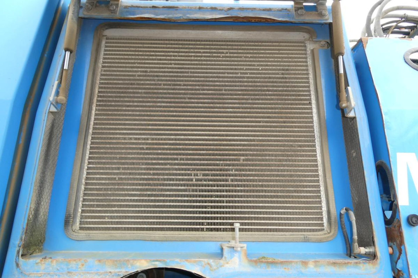 Radiator/grille area of a blue Terex MHL340D boom lift showing cooling radiator with protective frame and clamps.