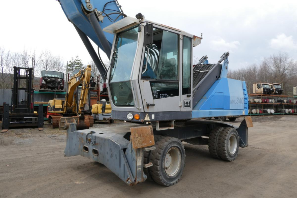 Terex MHL340D material handler truck in service showing cab, blue and gray body, boom arm, and front attachment.