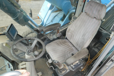 Terex MHL340D cab interior showing steering wheel seat controls and cabin window.