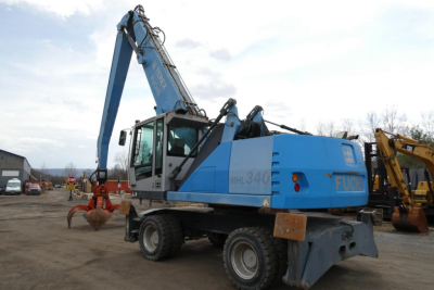 Terex MHL340D hydraulic excavator truck loader in blue with long boom and grapple, side view.