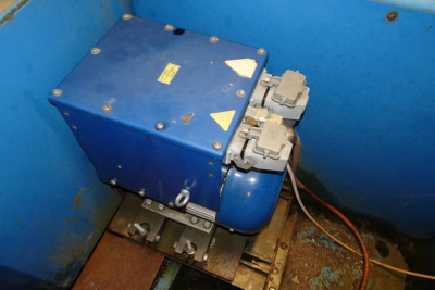 Blue hydraulic power unit with two grey electrical connectors inside a blue metal enclosure mounted in a recycling truck compartment.