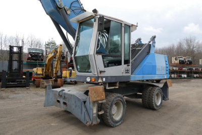 Terex MHL340D material handler truck in service showing cab, blue and gray body, boom arm, and front attachment.