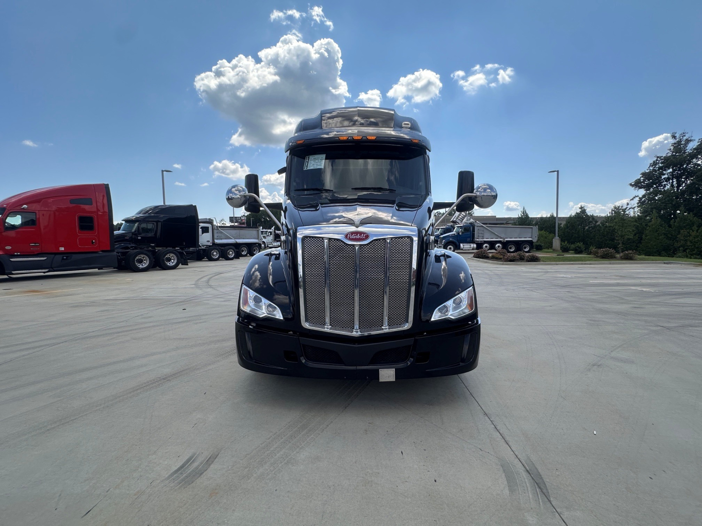 Peterbilt 579 conventional sleeper truck front view showing chrome grille and large bumper.