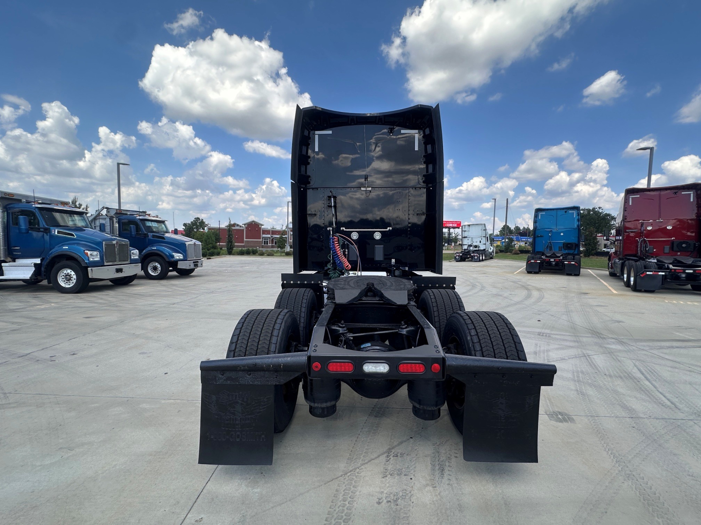 Peterbilt 579 chassis cab rear view showing fifth wheel and dual rear axles with mud flaps and rear lights.