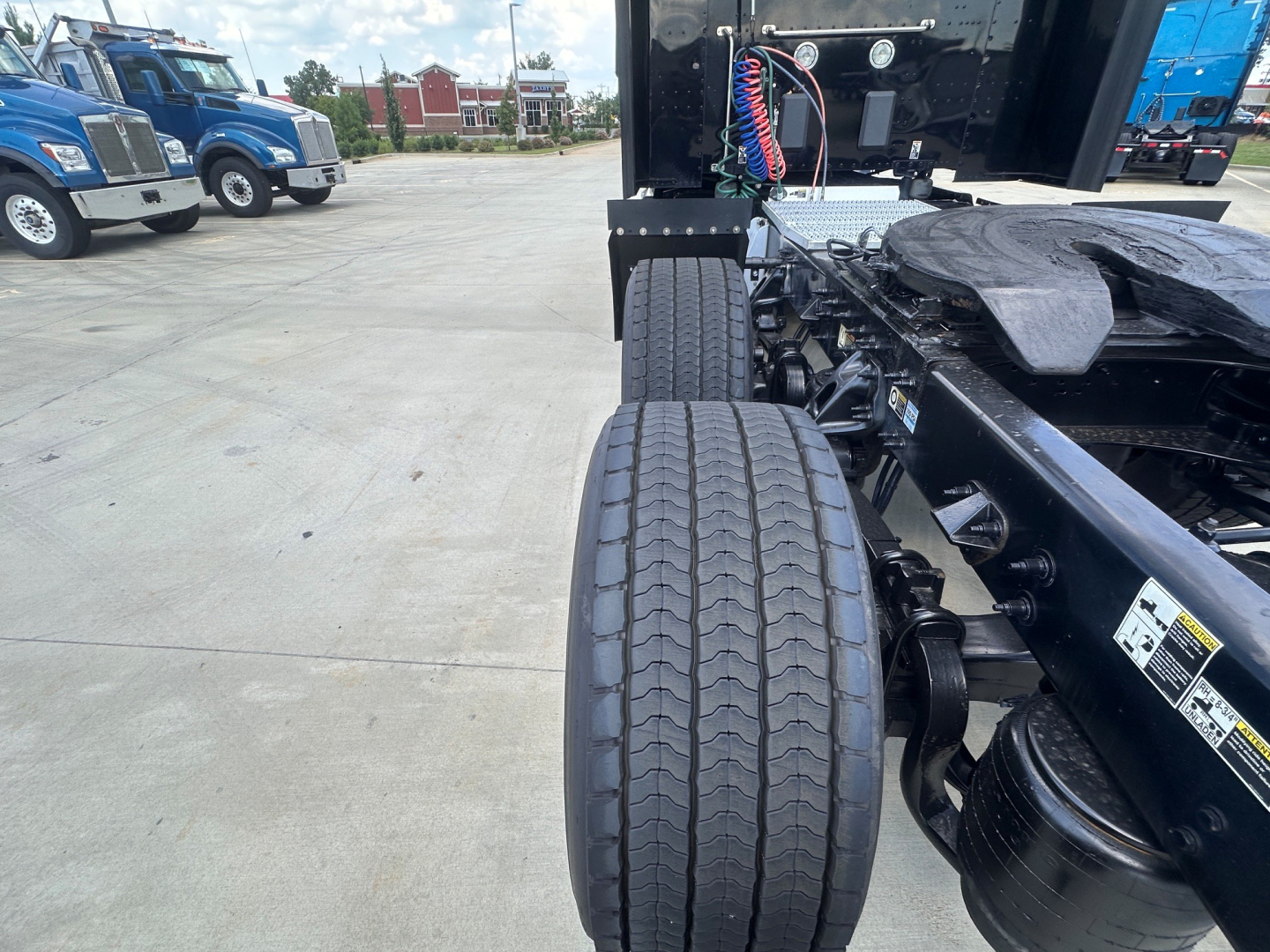 Peterbilt 579 tractor chassis and rear tires showing dual rear axles and frame with electrical harnesses and fifth-wheel area.
