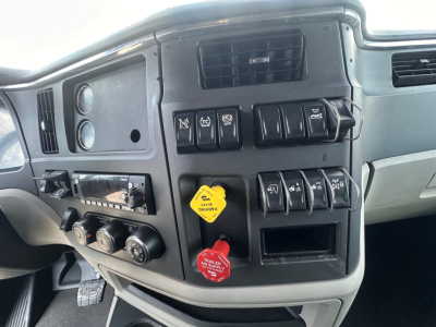 Peterbilt 579 dashboard area showing multiple switches, knobs, and red and yellow trailer air lines controls with circular dials.