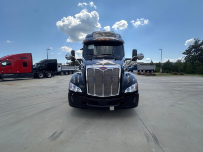 Peterbilt 579 conventional sleeper truck front view showing chrome grille and large bumper.