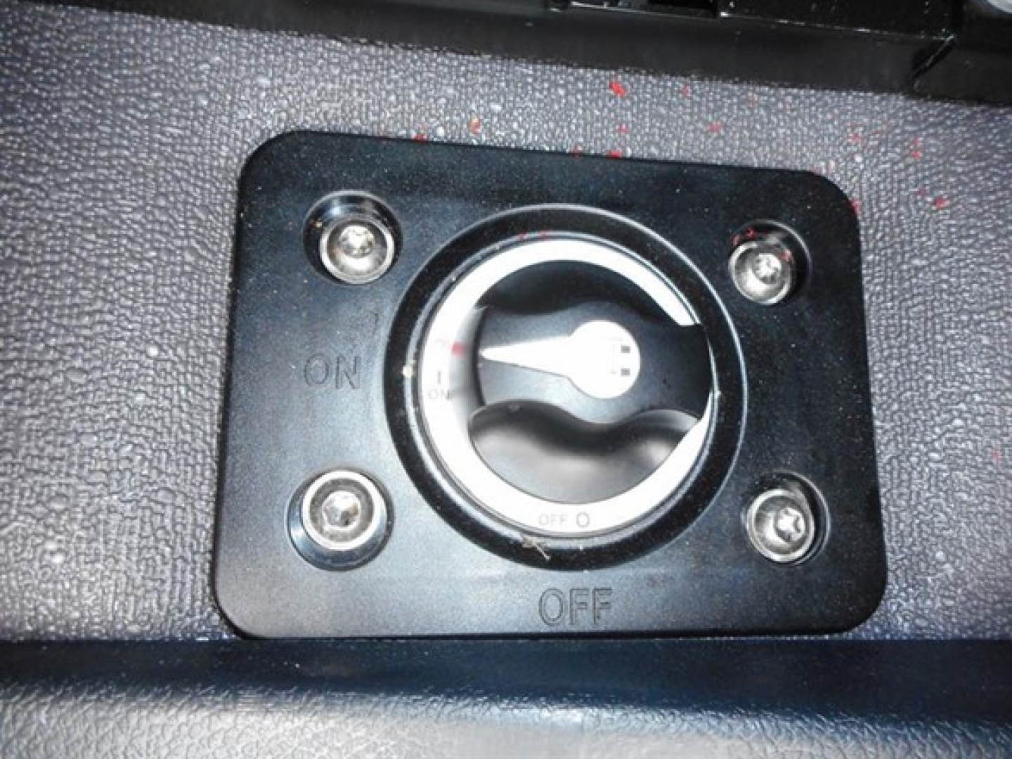 Conventional sleeper truck dash switch panel showing ON/OFF toggle with circular knob and four surrounding screws.