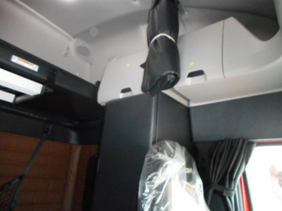 Freightliner Cascadia truck interior view showing sleeper cab with overhead storage and window shade.