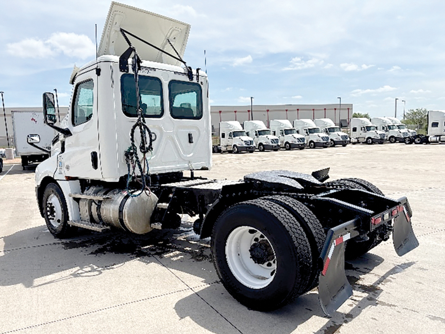 Truck chassis and cab of a 2020 Freightliner Cascadia126 in-service day cab, side rear view showing chassis, rear wheels, and absence of a complete trailer.