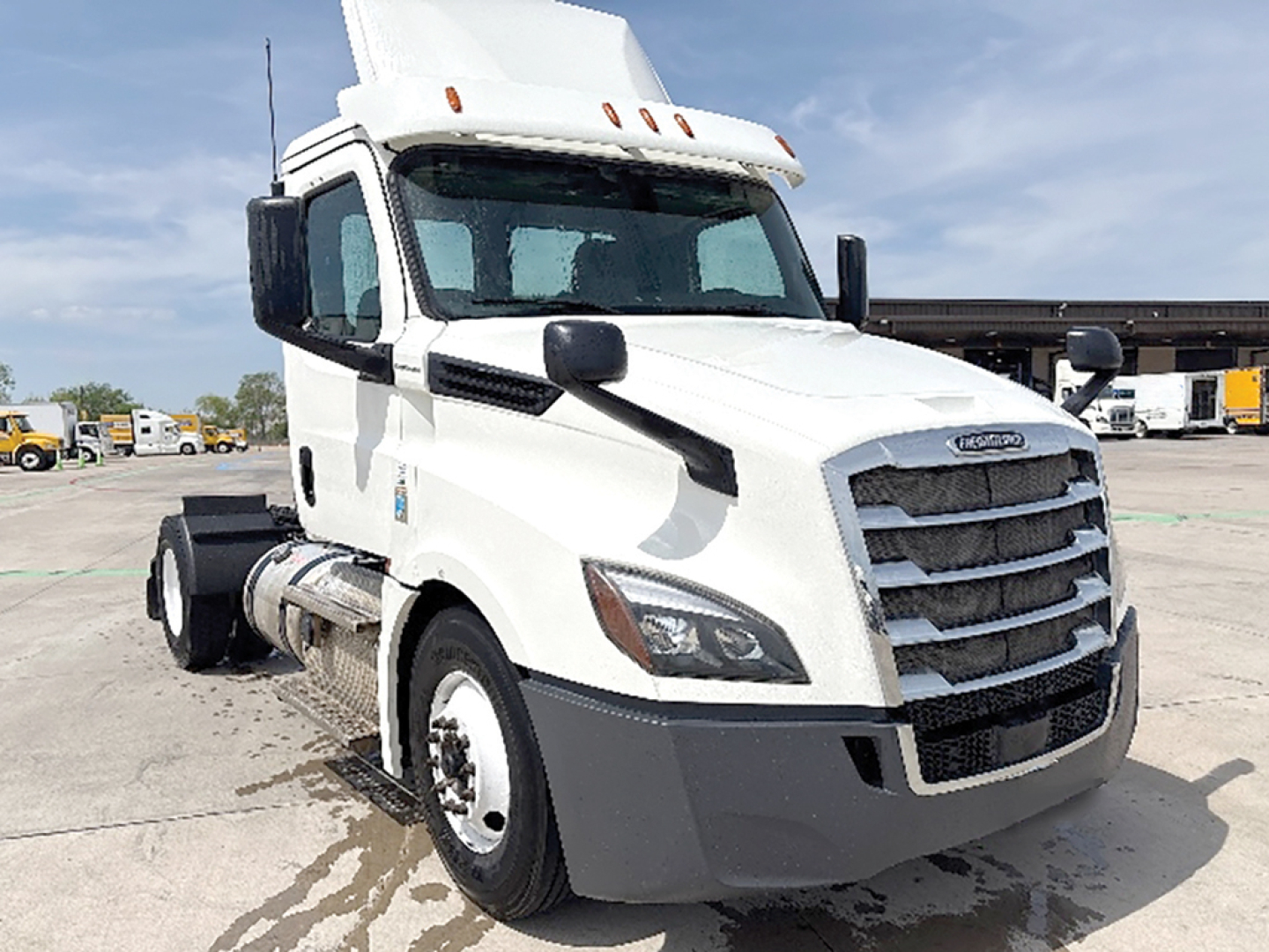 Freightliner Cascadia 126 daycab truck in white, front-right view, showing grille, headlights, and cab mirrors.