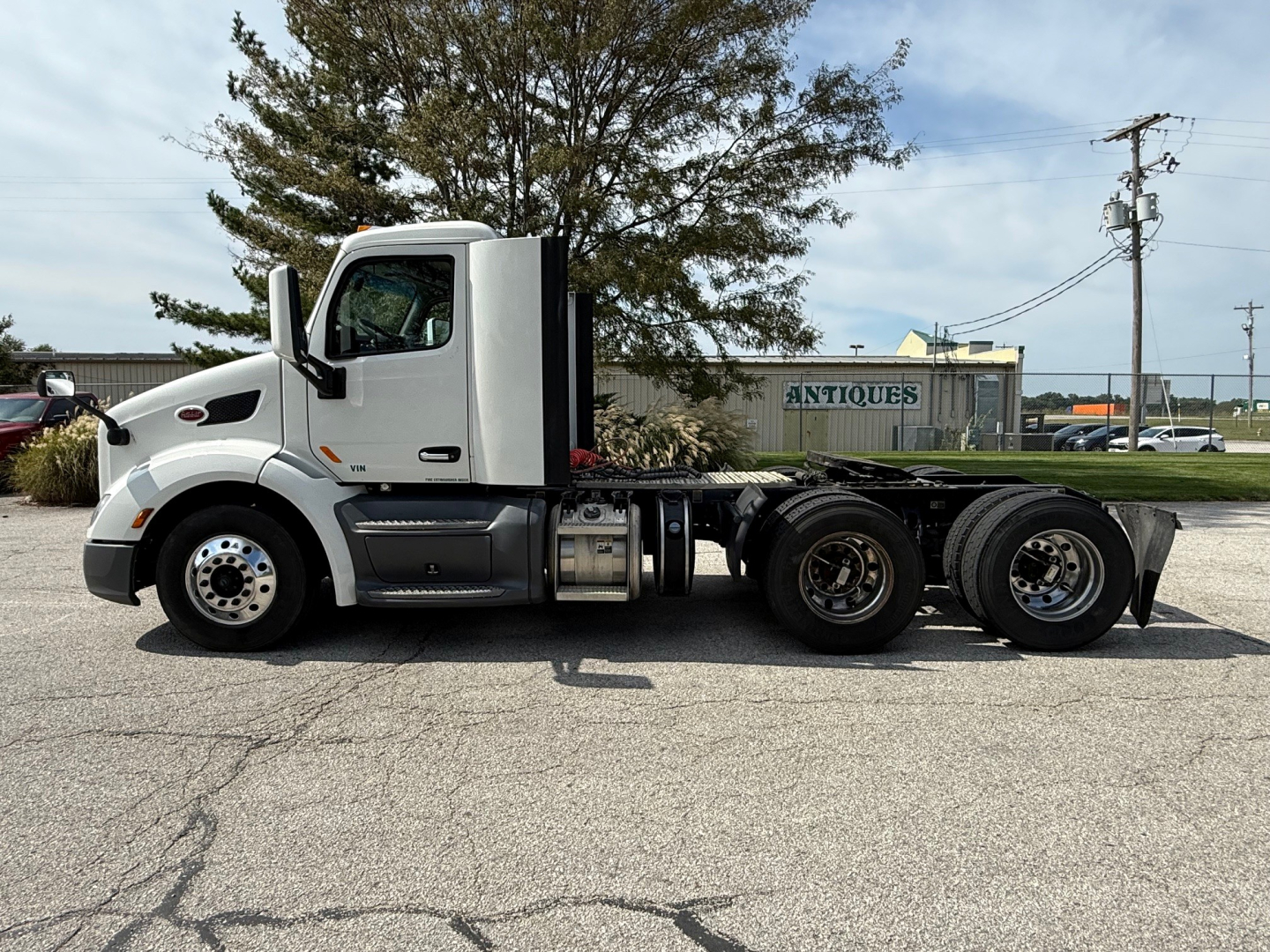 Peterbilt 579 conventional daycab tractor, side view showing 6x4 configuration with long sleeper chassis and attached components.