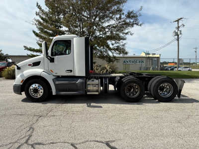 Peterbilt 579 conventional daycab tractor, side view showing 6x4 configuration with long sleeper chassis and attached components.
