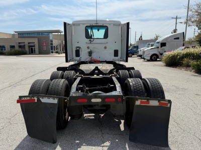 Peterbilt 579 tractor rear view showing fifth wheel hitch, dual rear axles, and mud flaps in a truck lot.