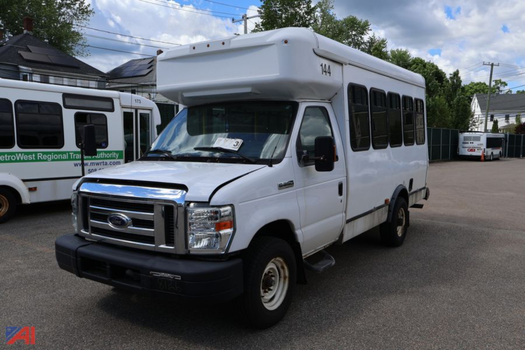 Ford E350 shuttle bus in white, front-side view showing roof wheelchair lift housing and passenger windows.