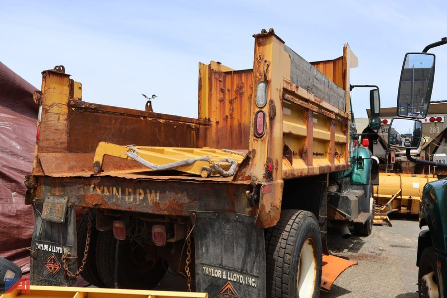 Heavy-duty dump truck bed of a 2007 International WorkStar 7400 dump truck showing rusty bed and rear taillights.